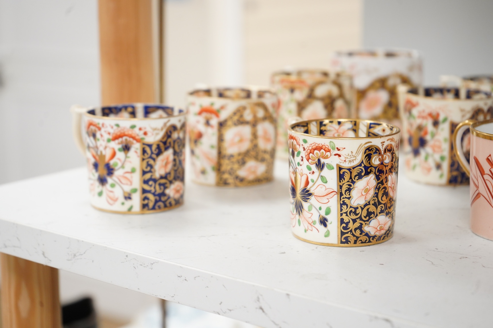 A collection of late 18th/19th century English and French porcelain coffee cans, tea cups and vases, some in Imari pattern